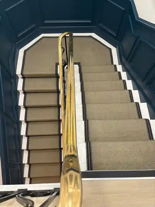 Beige herringbone stair carpet with black border