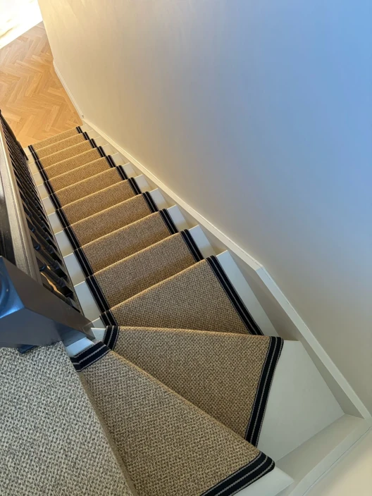 Beige stair runner with black borders, top-down view.