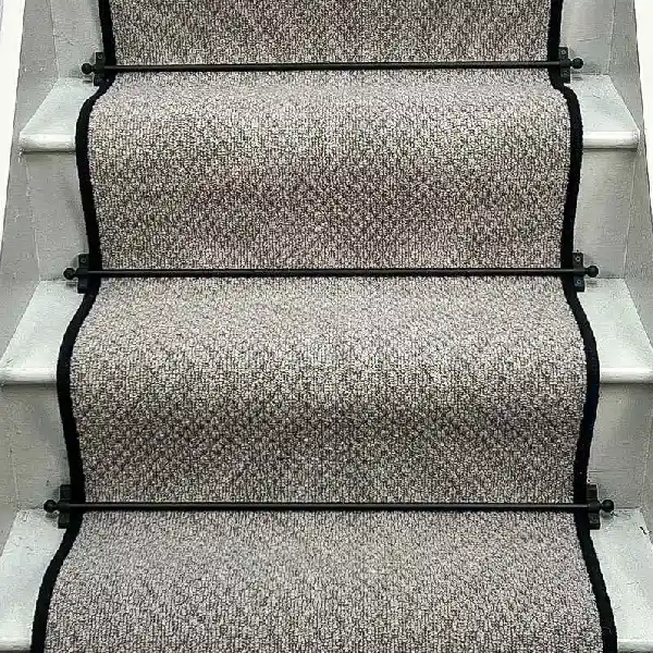 Charcoal Small Boucle Grey Wool Stair Runner with a black binding and black stair rods.