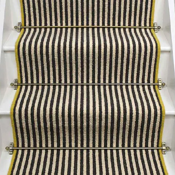 Gatsby wool stair runner with black and beige stripes, yellow edging, and brass stair rods. (2)